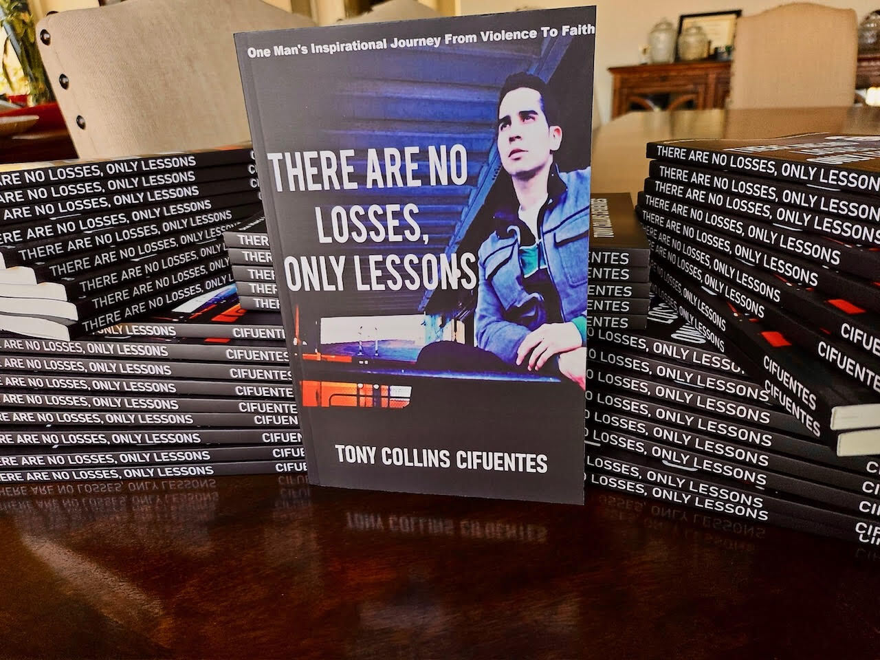Stacks of 'There Are No Losses, Only Lessons' books at a community signing