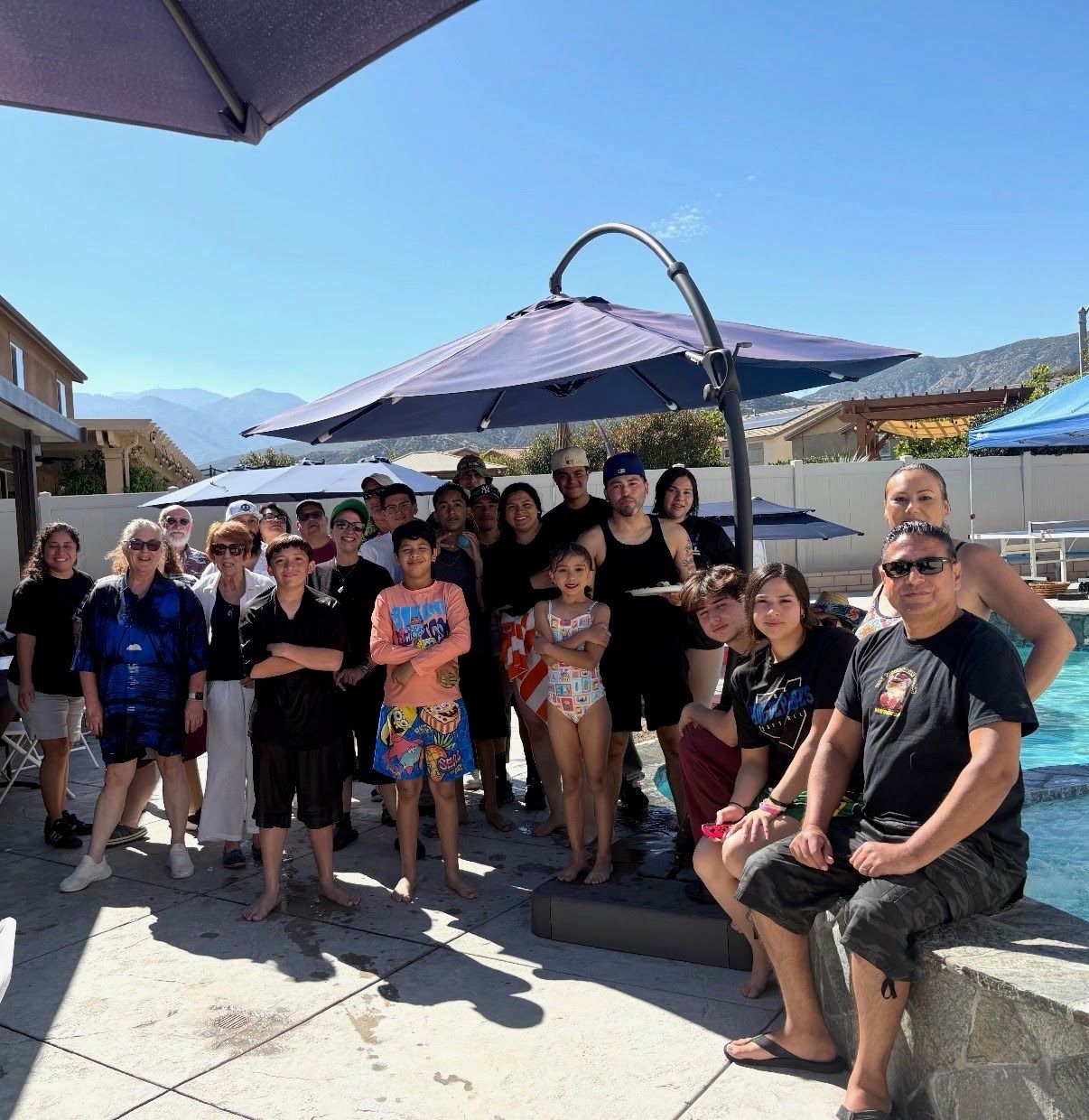 HBC IRON Youth Services group photo with youth, families, and coaches at the Pool Youth Outing
