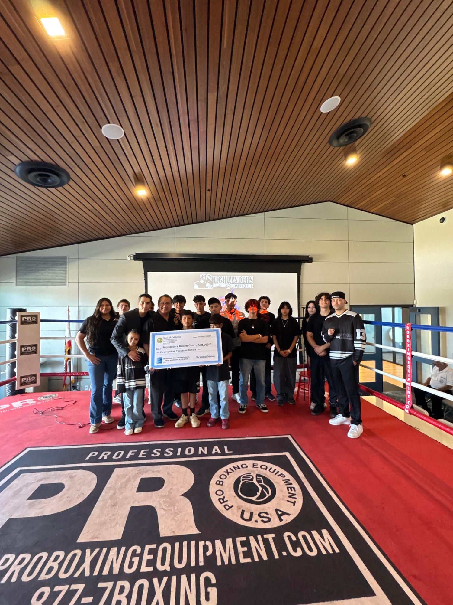 Group photo in the ring with the $500,000 State of California check made out to Highlanders Boxing Club