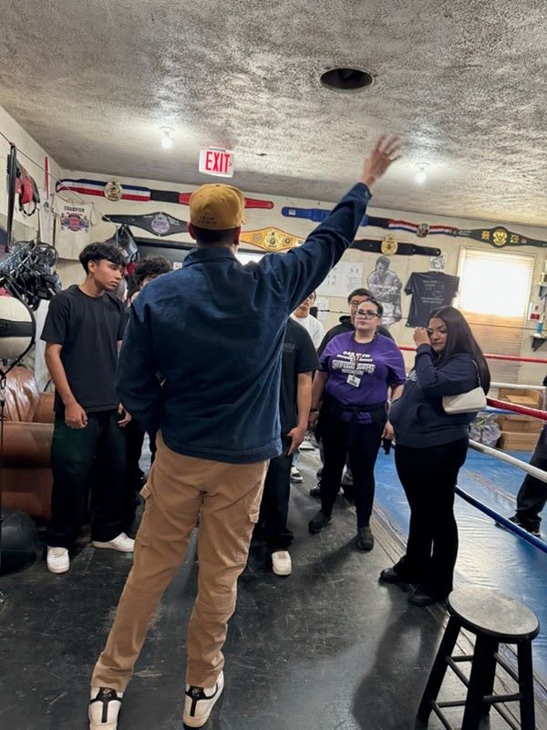 Coach mentoring young boxer at Highlanders Boxing Club